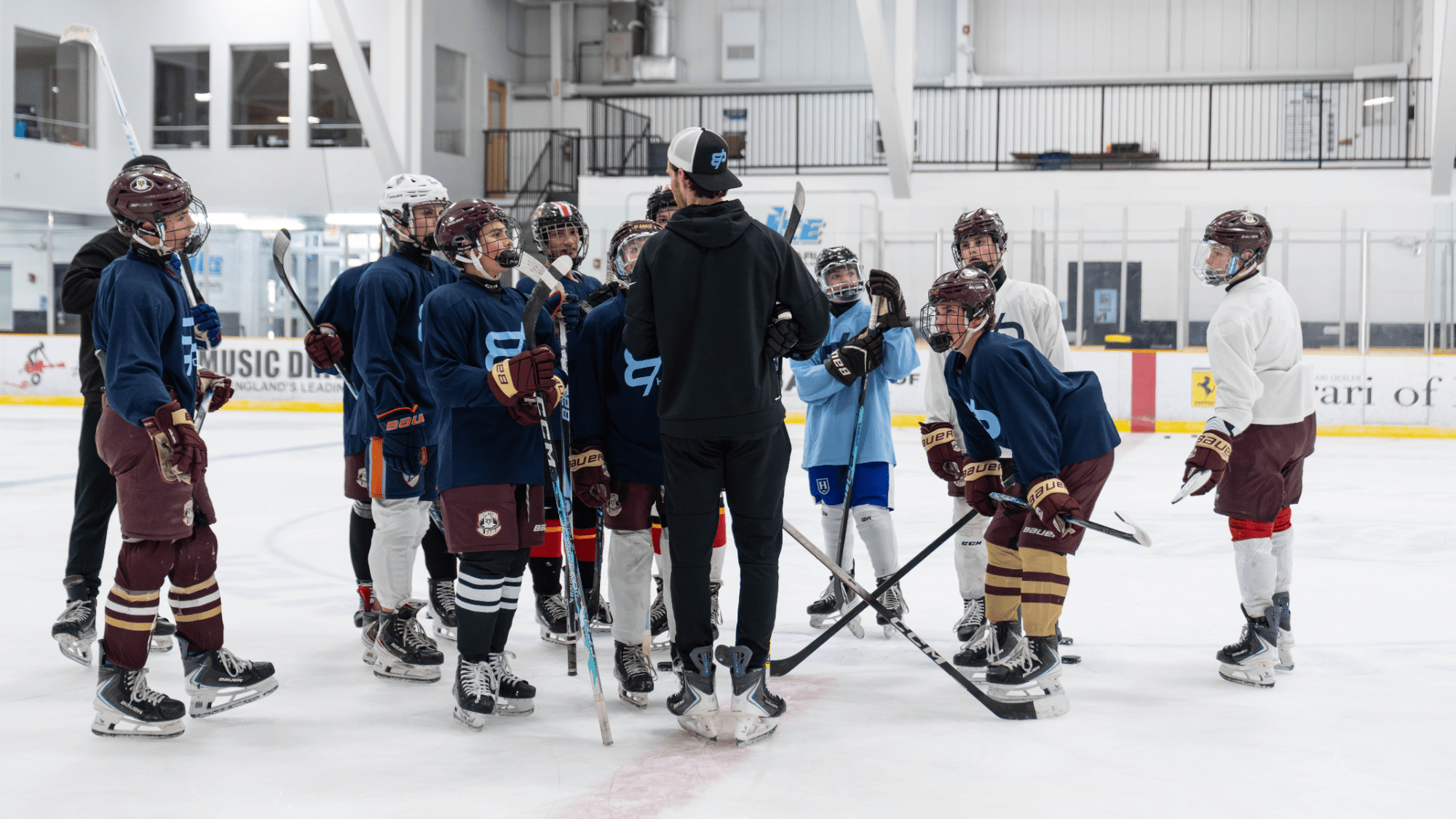 Coach addressing a group of young players on the ice